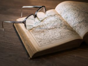 glasses on an open book with a map inside