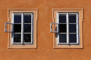 two identical 6-paned windows in an adobe-like wall