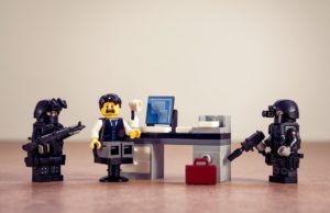 lego man at desk with lego police surrounding him
