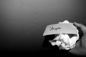crumpled paper with the word hope, in a hand